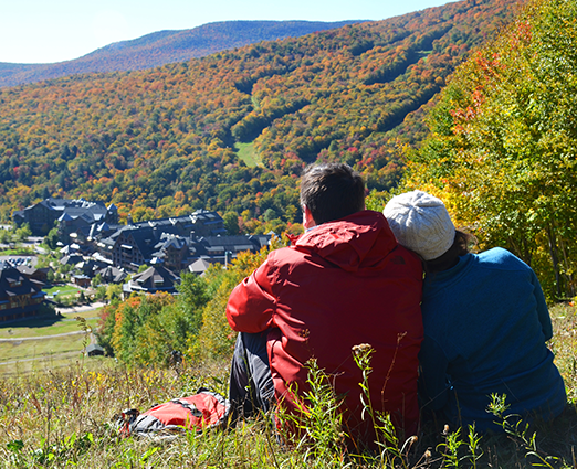 Couple looking over valley of fall foliage