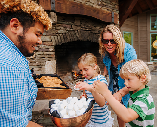 Employee serving s'mores ingredients to family