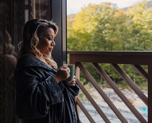 woman holding coffee cup looking out a window