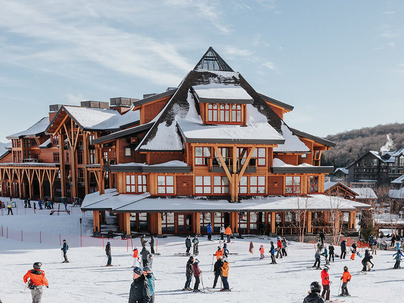 Chalet view in the winter with skiiers and snowboarders milling around