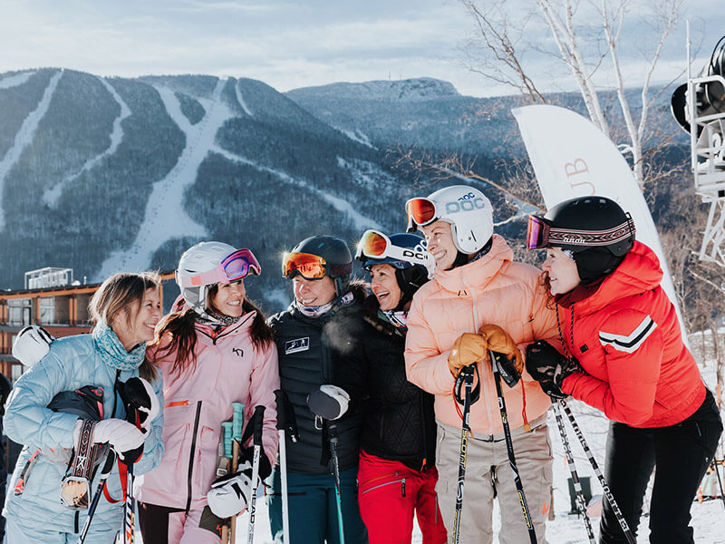 Women in skiing gear smiling together on a wintry day