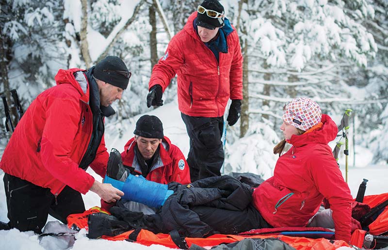 men helping person with foot injury