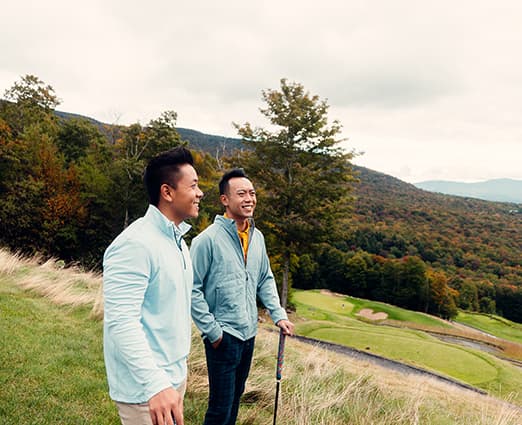 Two golfers looking on