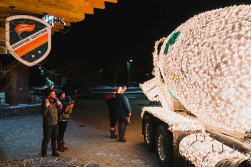 A festively lit cement truck in the dark