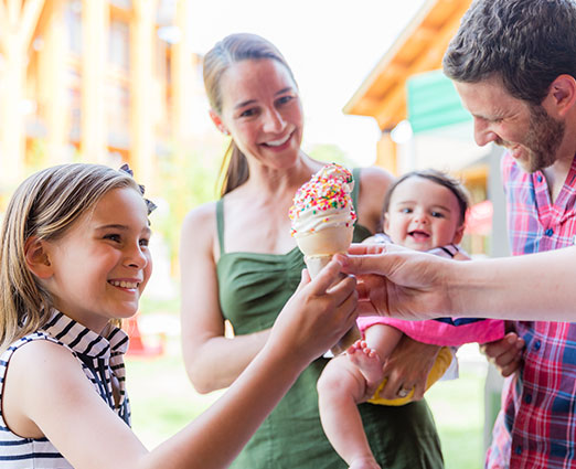 Family enjoying a creemee ice cream on the green