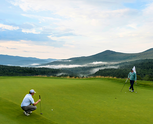 Two men playing golf in the mountains